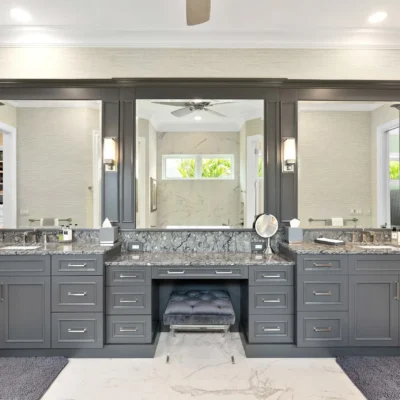 Contemporary bathroom featuring a floating dark vanity with a wooden countertop, illuminated by pendant lights and decorated with monochromatic wall art and a vase of branches.