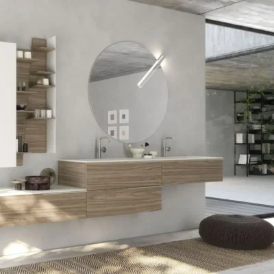 Modern bathroom with floating wooden vanity, large round mirror, and open shelving, featuring minimalist decor and a large window offering natural light